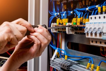 The man is repairing the switchboard voltage with automatic switches. The man is repairing the switchboard voltage with automatic switches. Electrical background